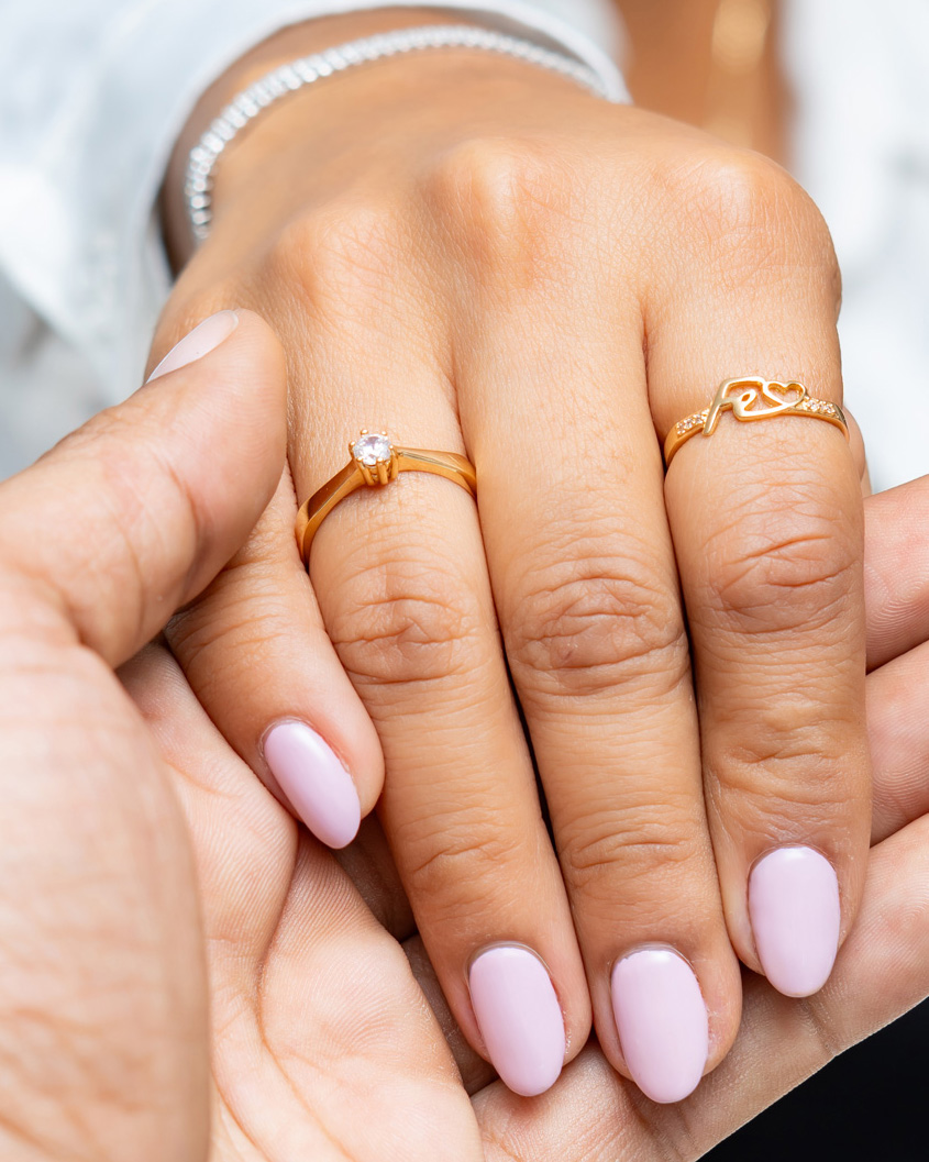 Anillos Norela en oro 18K en manos entrelazadas